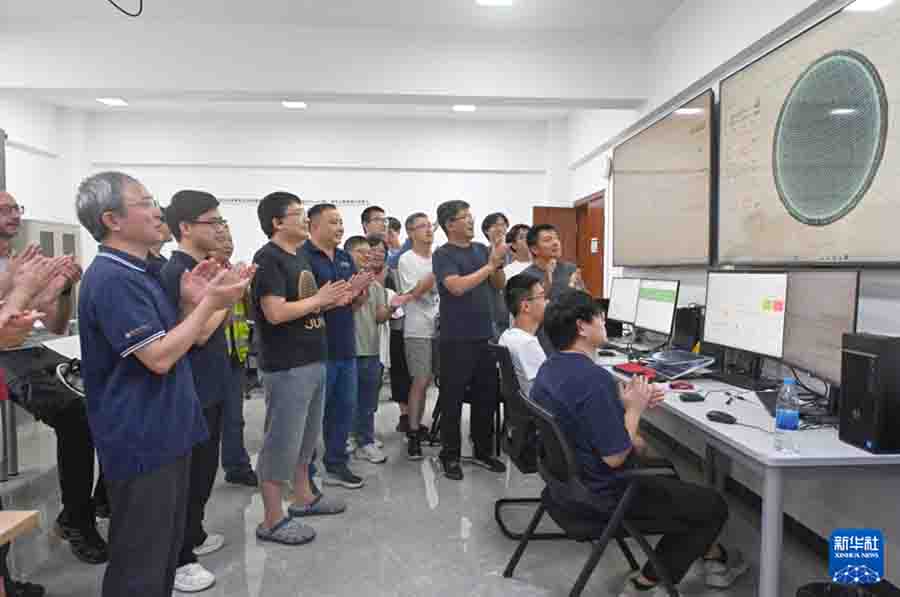 8月26日，科研人员在江门中微子实验运行控制室共同开启物理取