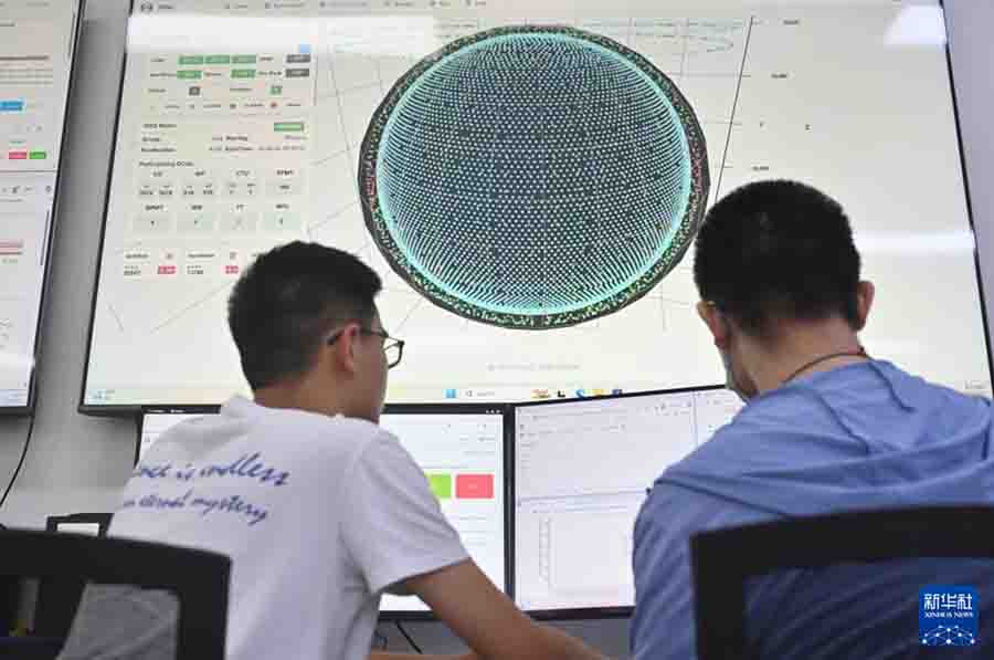 8月26日，科研人员在江门中微子实验运行控制室共同操作启动物